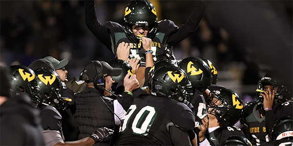 WSU football players holding a teammate up in celebration